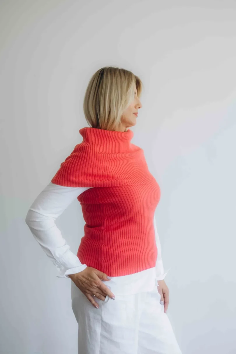 Dámske oblečenie dvojset RAGNILD červeno-oranžovo lososový – bočný pohľad. Popis: Bočný pohľad zvýrazňuje ženskú siluetu a jemné línie dvojsetu RAGNILD v teplom lososovom odtieni.