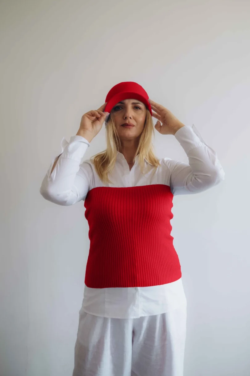 Modelka v bielom outfite s červeným pleteným dvojsetom MAGNHILD – driekovník a čiapka TATTJA, pohľad spredu