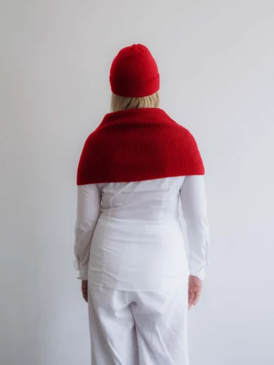 Modelka v bielom outfite TATTJA s červeným pleteným dvojsetom INGEBORG – nákrčník a čiapka, pohľad zozadu