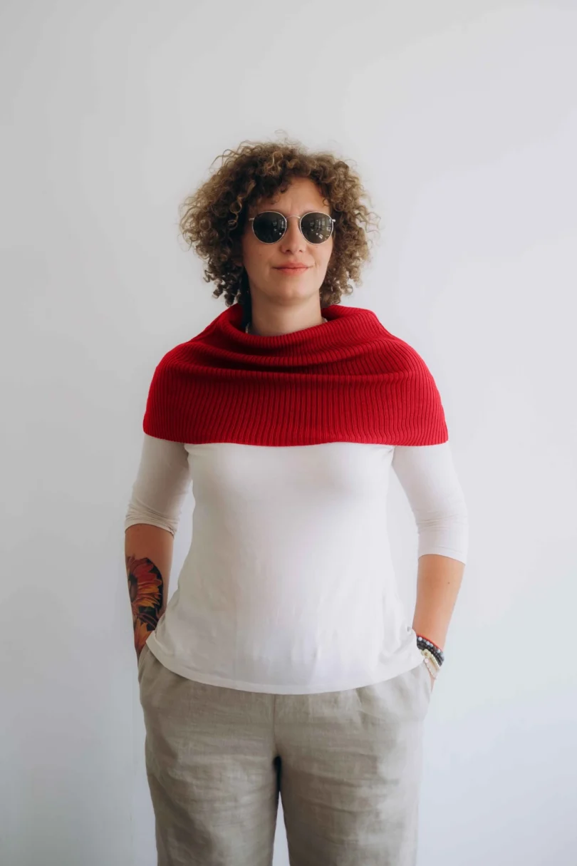 Modelka v bielom outfite s červeným pleteným nákrčníkom TANJA značky TATTJA, pohľad spredu