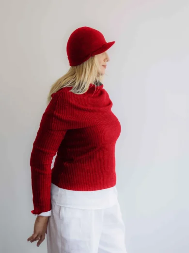 Modelka v bielom outfite s červeným pleteným štvorsetom TATTJA – nákrčník, driekovník, rukávniky a čiapka, pohľad zboku