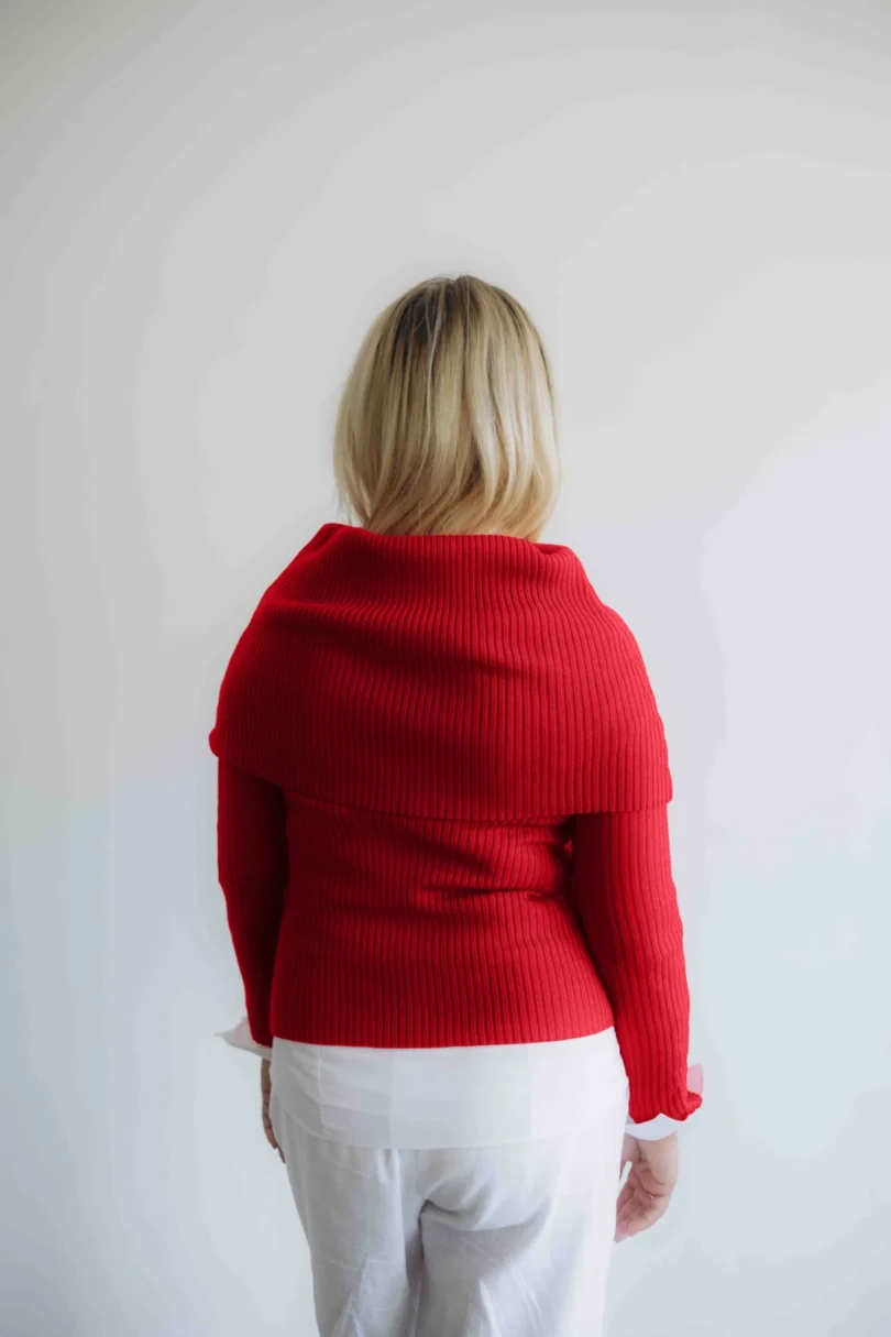 Modelka v bielom outfite s červeným pleteným trojsetom DAKIN značky TATTJA – nákrčník, driekovník a rukávniky, pohľad zozadu