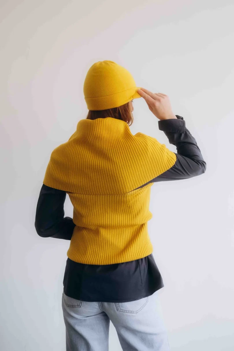 Dámsky trojset SOLVEJ horčicovo-žltý – pohľad zozadu na elegantný pletený komplet TATTJA so ženskou siluetou a mäkkou štruktúrou úpletu.