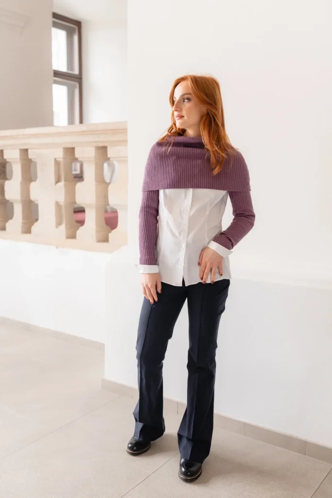 Woman wearing purple knit accessories styled with a white shirt and dark trousers in an elegant outfit