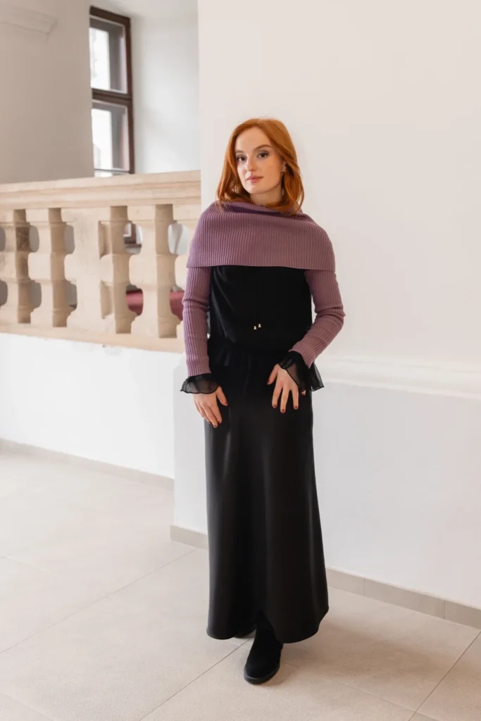 Elegant full outfit with purple knit accessories styled over a long black dress